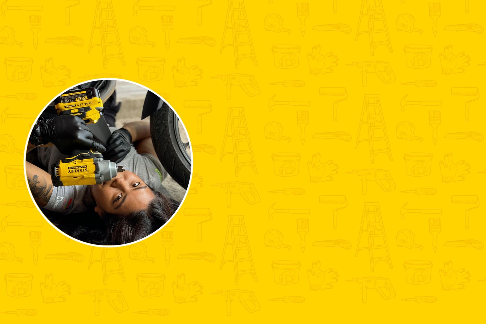 Una persona trabaja debajo de un vehículo utilizando herramientas manuales amarillas STANLEY, con el rostro difuminado por privacidad. El fondo es amarillo con contornos de herramientas y equipo.
